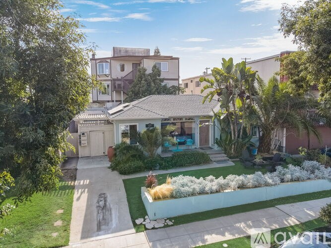 A house with a well-maintained garden and a clear sky.