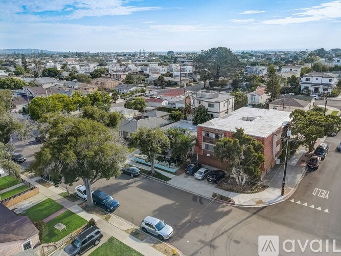 A street view of a residential area with houses and parked cars.
