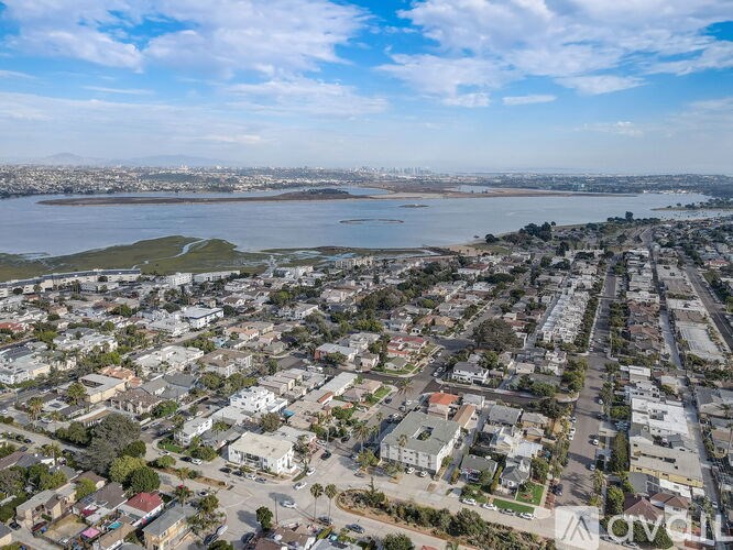 A bird's eye view of a residential area with a large body of water in the background.