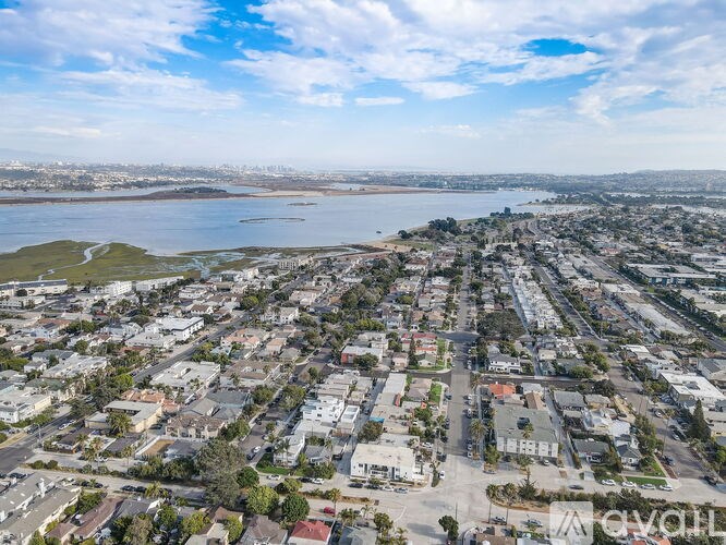 A bird's eye view of a residential area with a large body of water in the background.