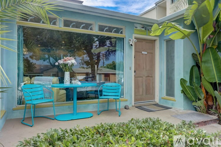 A blue table and chairs are set up on a patio.