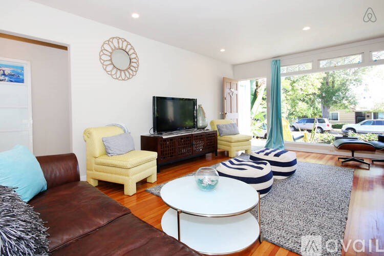 A living room with a brown leather couch and a white coffee table.