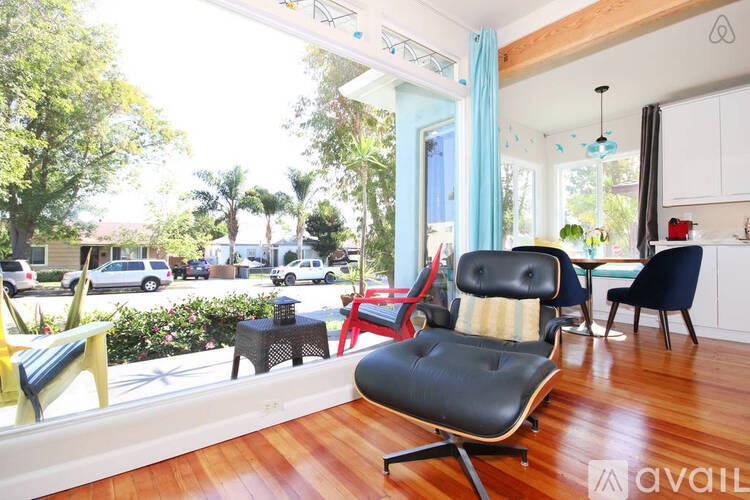 A living room with a black chair in the middle of the room.