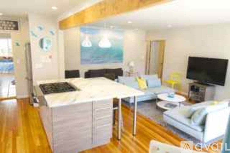 A modern living room with a white couch and a television.