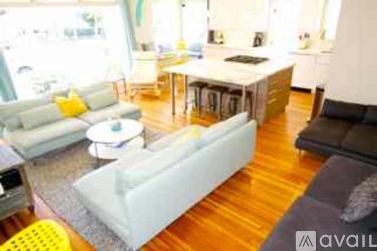 A living room with a white couch and a grey couch.