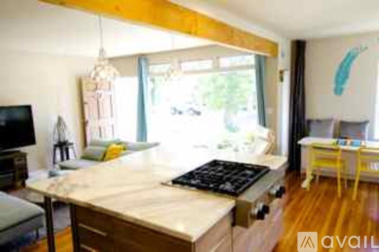 A kitchen with a marble countertop and a TV on the left side.
