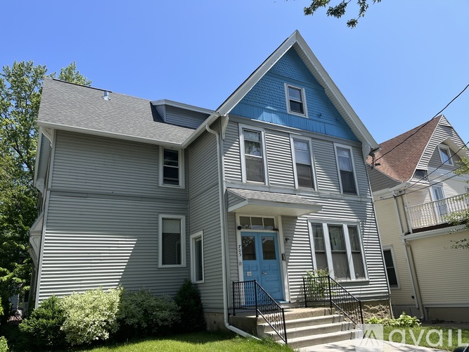 A house with a blue door and a grey facade.