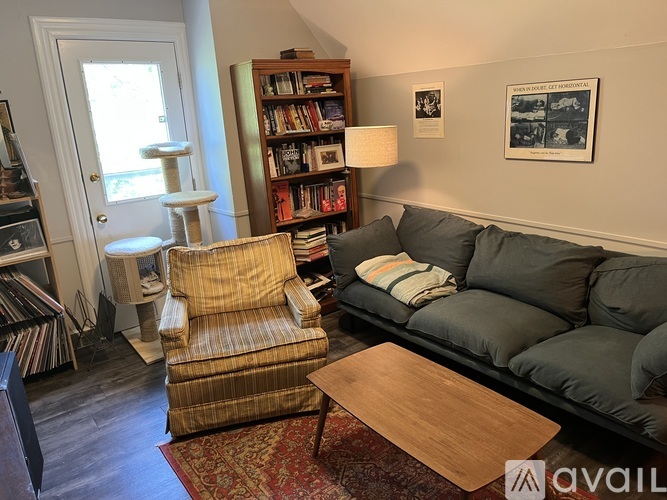 A living room with a grey couch, a striped armchair, and a wooden coffee table.