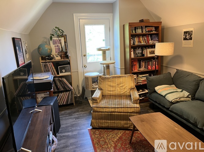 A living room with a couch, chair, and bookshelves.