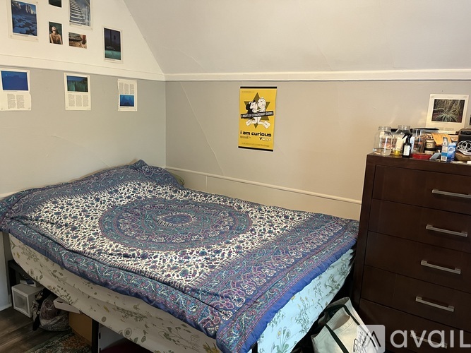A bedroom with a bed, a dresser, and pictures on the wall.