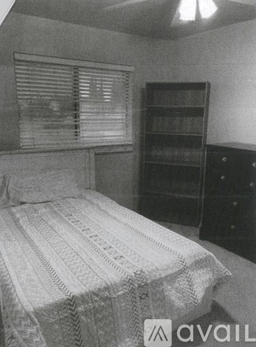 A bedroom with a bed, dresser and bookshelf.