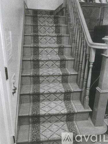 A staircase with a diamond patterned runner.