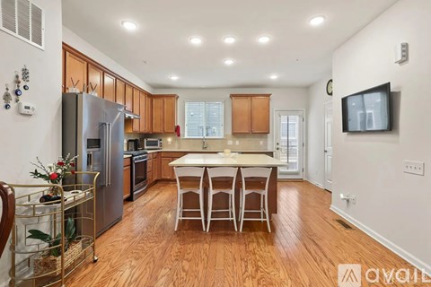 A kitchen with wooden floors and a white table with four chairs.