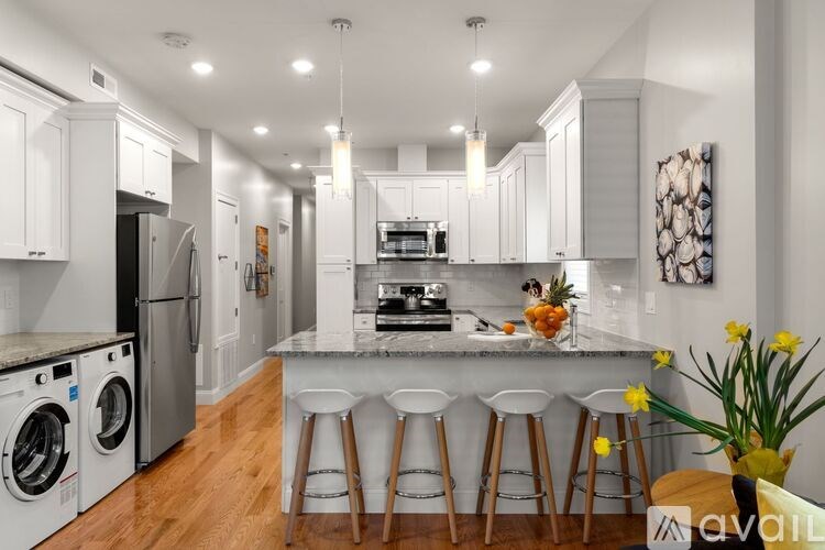 A kitchen with a bar area and a washer and dryer.