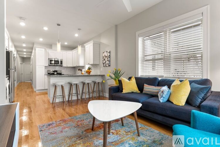 A living room with a blue couch and a white coffee table.