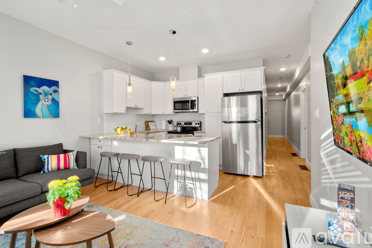 A modern kitchen with white cabinets and stainless steel appliances.