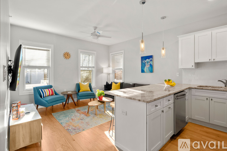A kitchen with a blue chair and a fan.