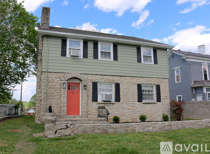 A house with a red door and a stone wall.