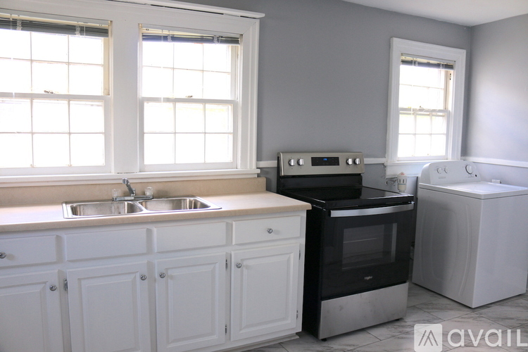 A kitchen with white cabinets and a black oven.