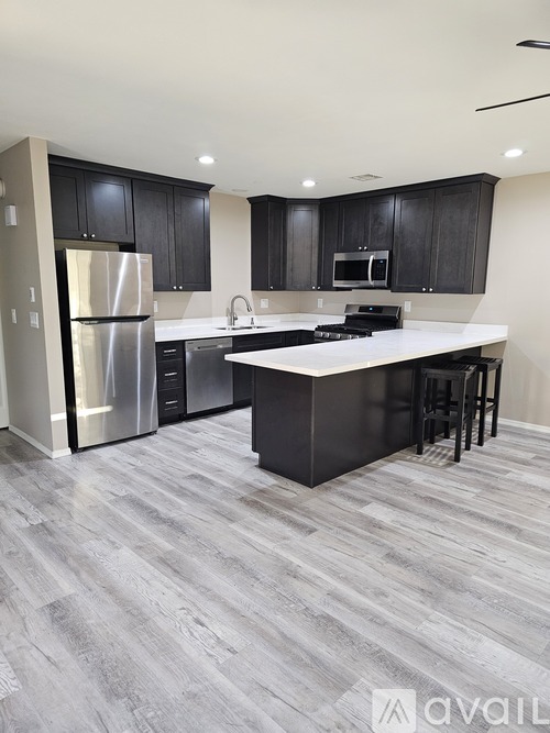 A modern kitchen with a large island and stainless steel appliances.