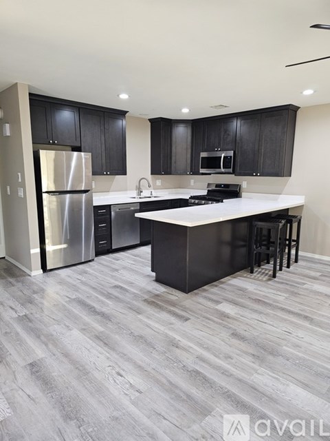 A modern kitchen with a large island and stainless steel appliances.