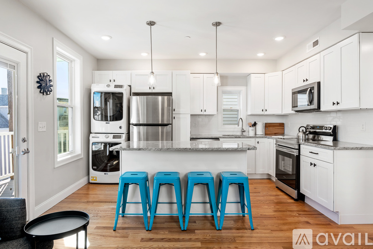 A kitchen with white cabinets and a black table.