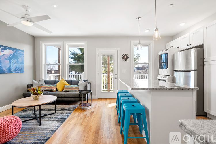 A modern kitchen with a dining table and blue stools.