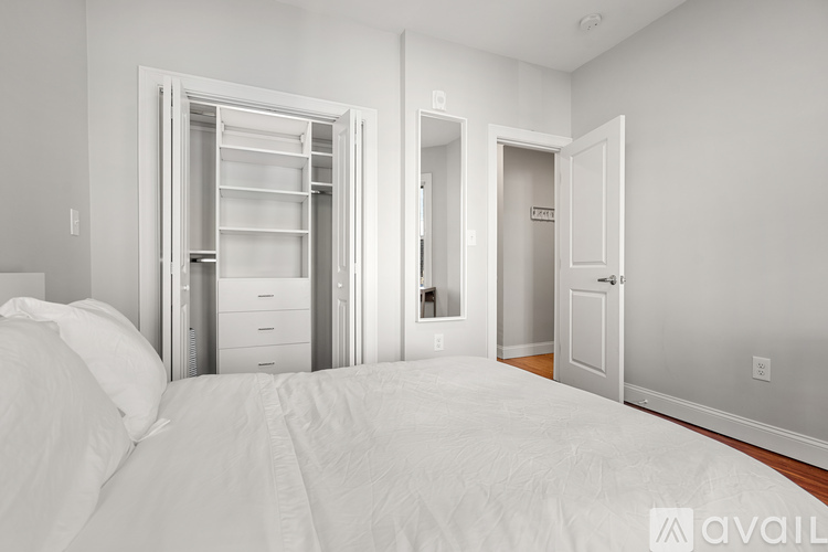 A bedroom with a large bed and a walk-in closet.