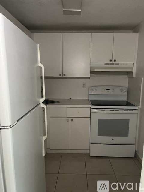 A white refrigerator and oven in a kitchen.