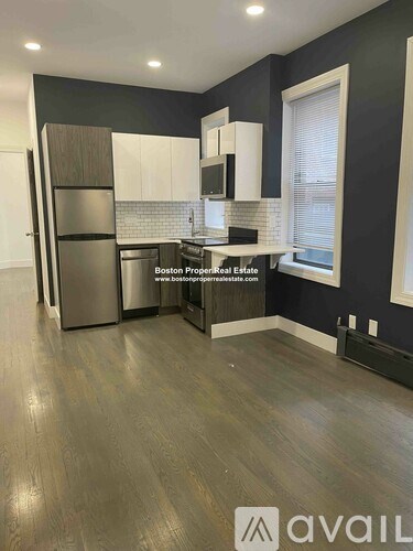 A kitchen with dark wood floors and a stainless steel refrigerator.