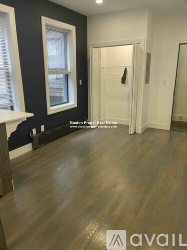 A room with wooden flooring and a white door.