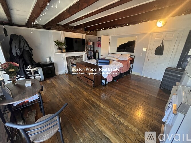 A living room with wooden floors and a fireplace.