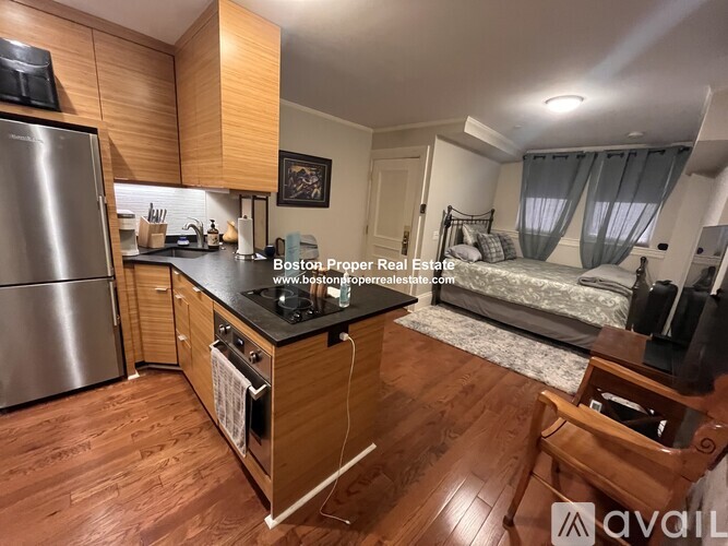 A kitchen with wooden cabinets and a stainless steel refrigerator.