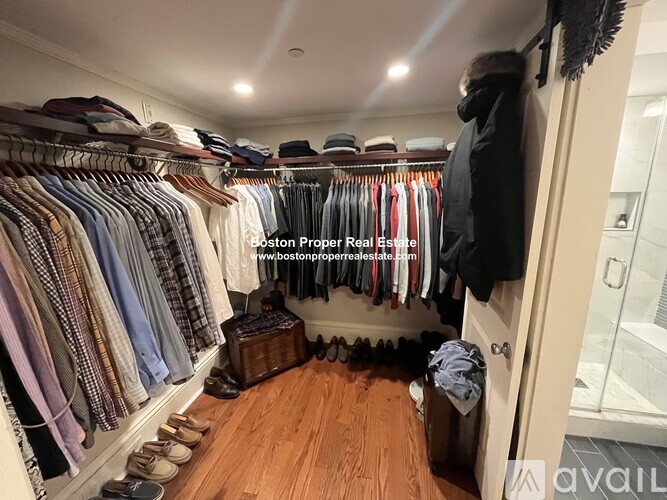 A walk-in closet with clothes and shoes.