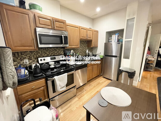 A kitchen with wooden cabinets and a stove top oven.