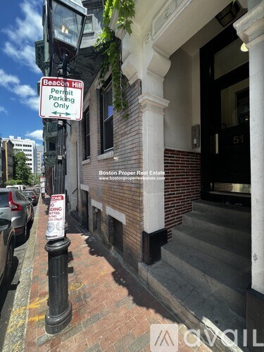 A parking sign on a pole outside a building.
