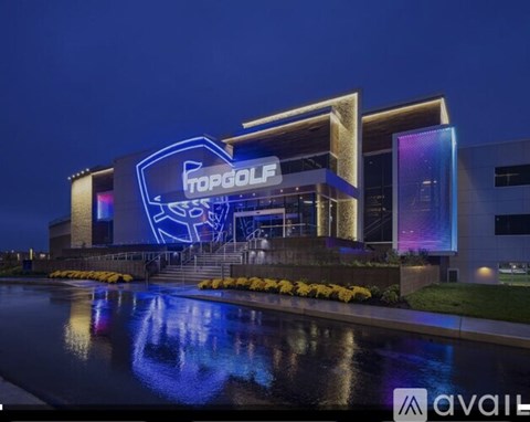 A building with a blue neon sign that says TopGolf.