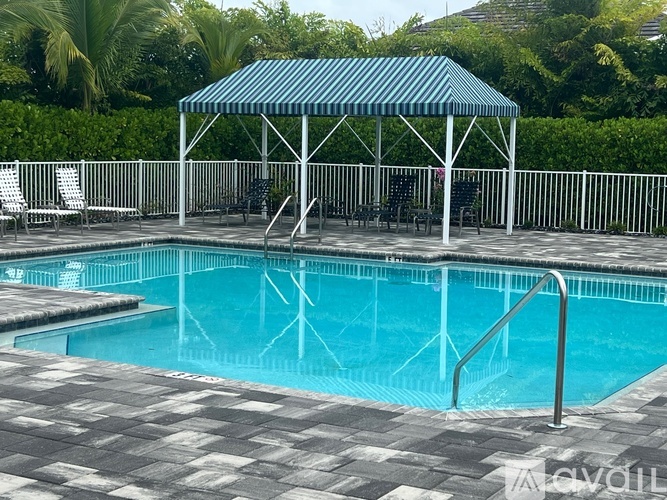 A pool with a blue cover and a white fence.