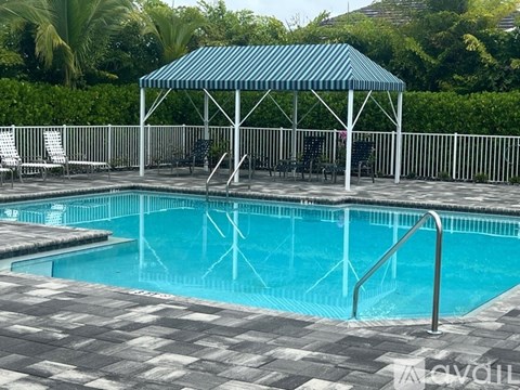 A pool with a blue cover and a white fence.