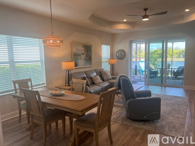A well-lit dining area with a table set for two and a view of the backyard.