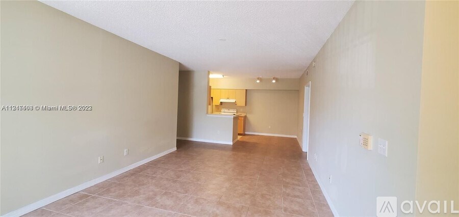 Empty room with beige walls and carpeting, available for rent or sale.