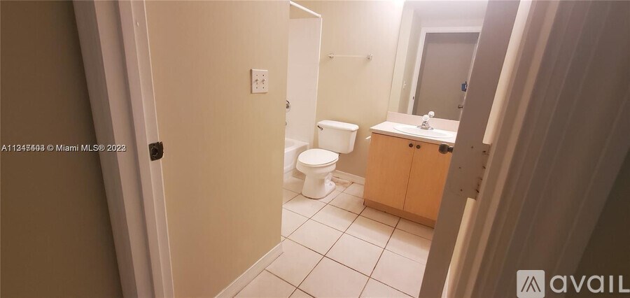 A bathroom with a toilet, sink and mirror.