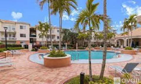 A pool surrounded by palm trees and lounge chairs.