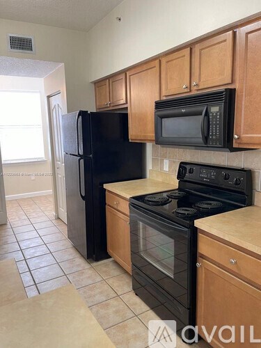 A kitchen with black appliances and wooden cabinets.