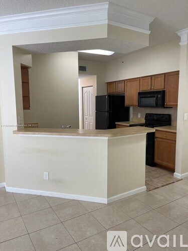 A kitchen with a black refrigerator, black microwave, and black stove.