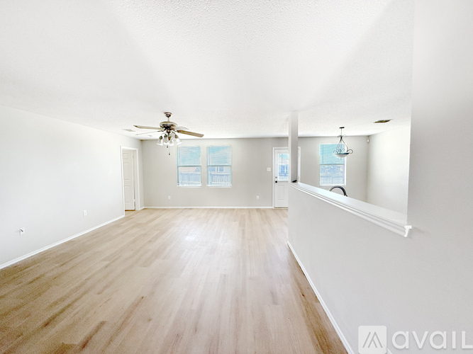 A spacious room with a ceiling fan and carpeted floor.