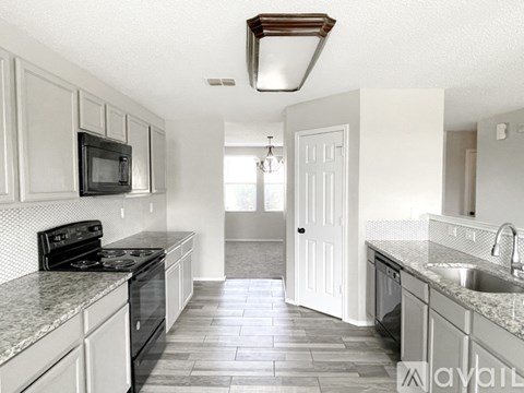 A kitchen with a black stove top oven and a black microwave.