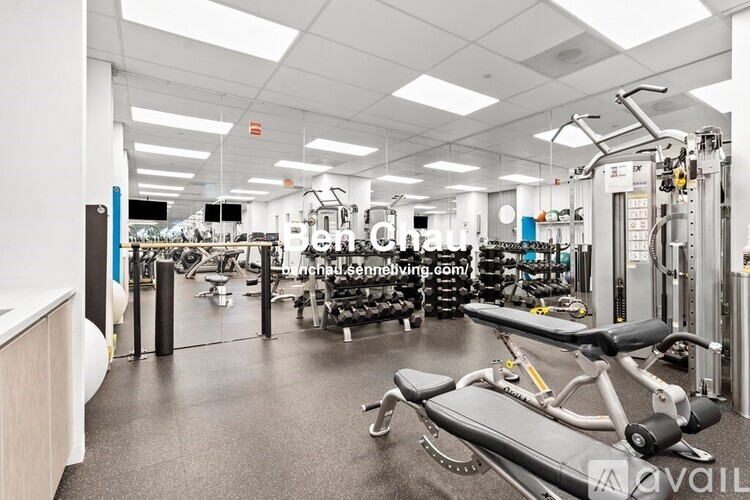 A gym with a variety of equipment including treadmills, weights, and exercise machines.