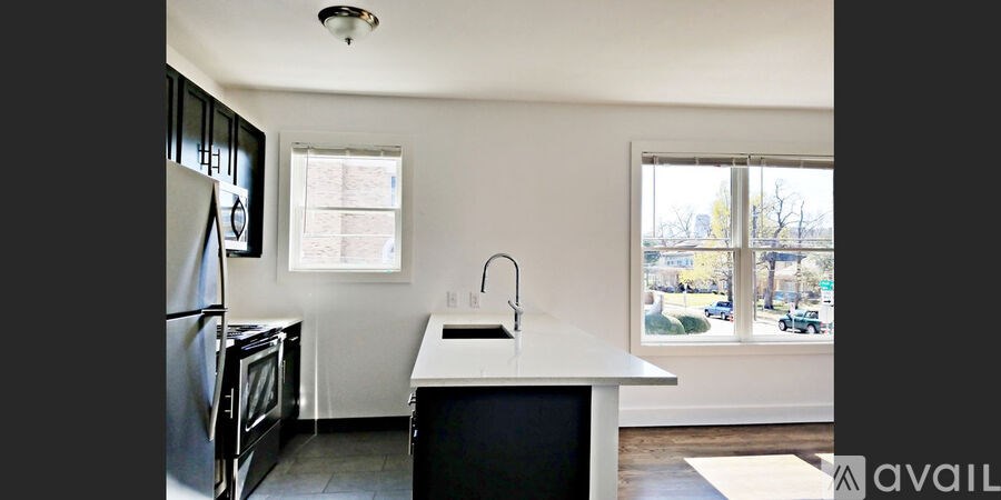 A kitchen with a black fridge and a white counter.
