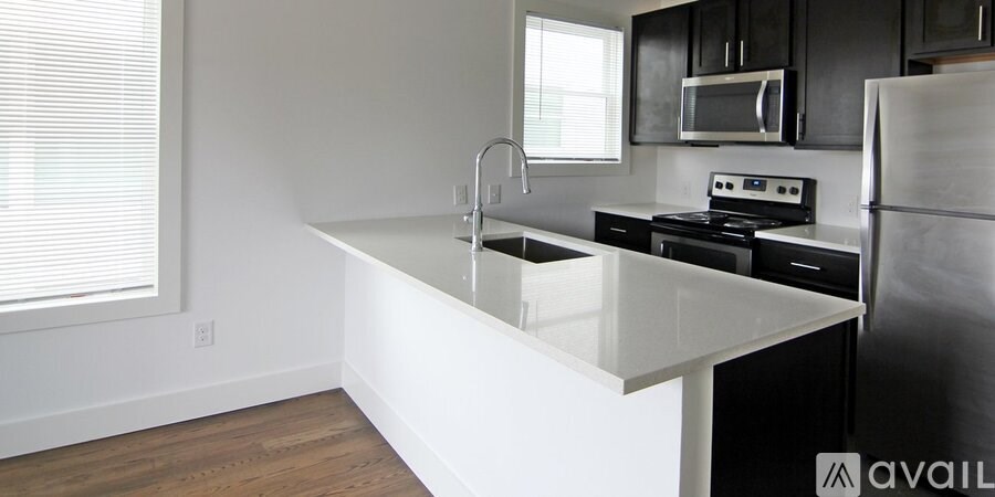 A kitchen with a white countertop and black cabinets.
